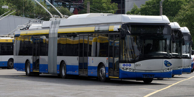 Blau-weiß-gelber Batterie-Oberleitungsbus der Stadtwerke Solingen, Wagen 862, vor weiteren O-Bussen auf dem Betriebsgelände.