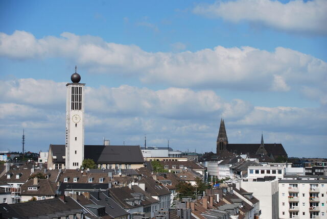 Blick über Dächer der Solinger Innenstadt mit dem hellen Turm der evangelischen Stadtkirche links und St. Clemens rechts.